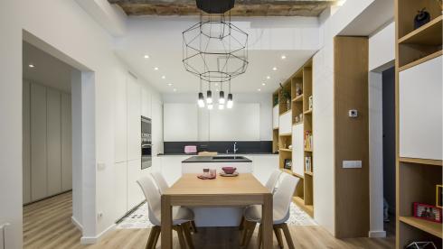 Cocina blanca, con isla y abierta equipada con muebles diseñados por Santos