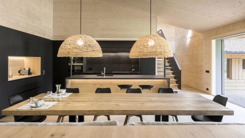 Cocina negra con isla y abierta al salón equipada con muebles diseñados por Santos
