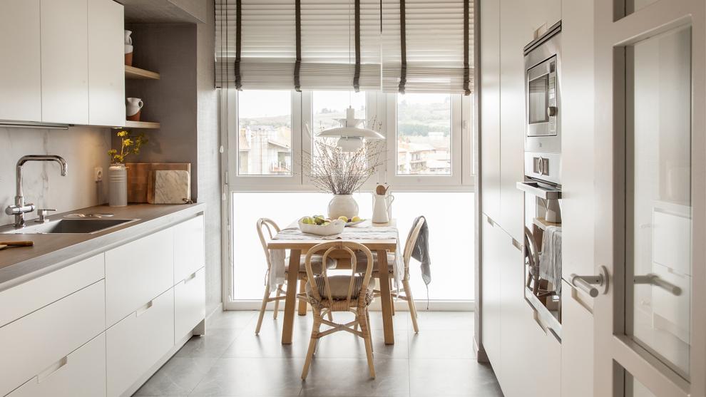 Cocina blanca en paralelo equipada con muebles diseñados por Santos