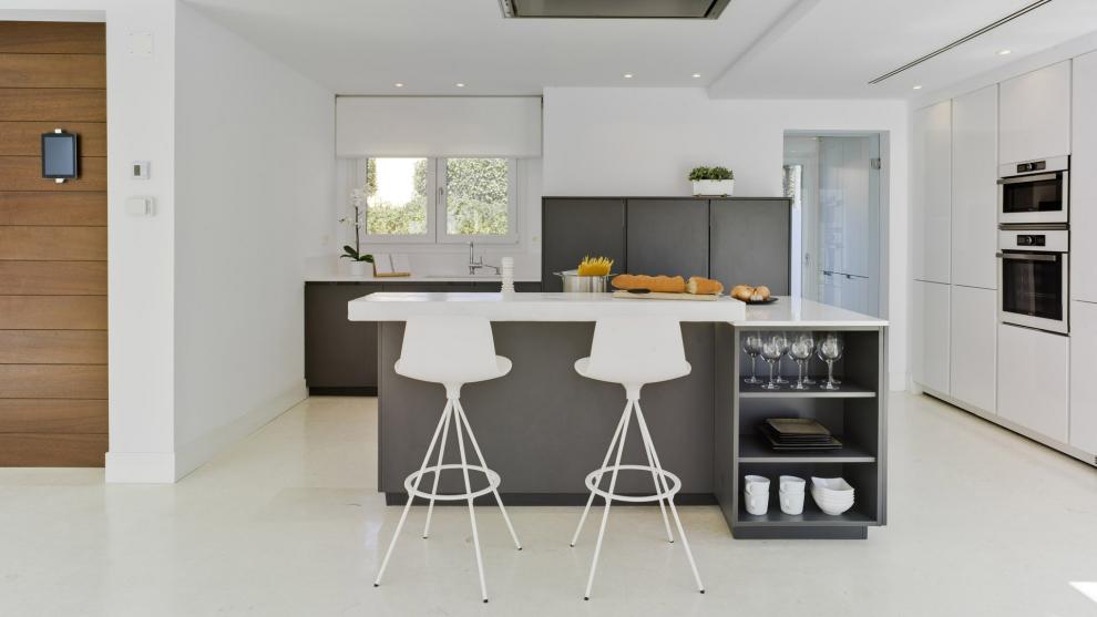 Cocina gris con isla y abierta al salón equipada con muebles diseñados por Santos