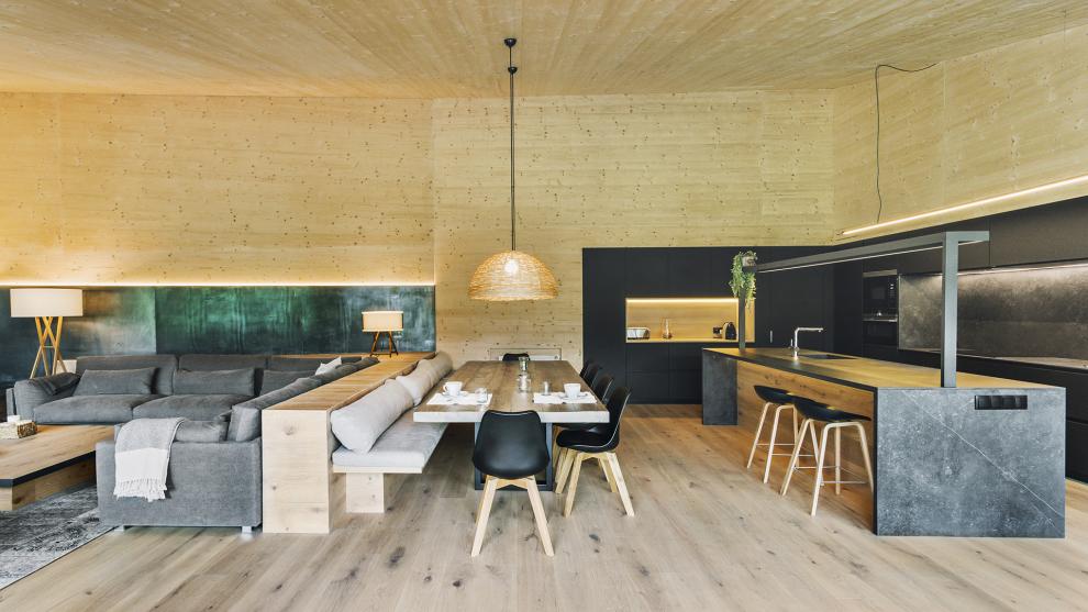 Cocina negra con isla equipada con muebles diseñados por Santos